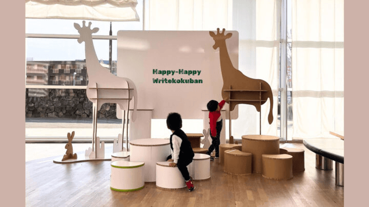 Re-board®で製作したキリン型パーティションとテーブル・椅子の子ども向け什器展示