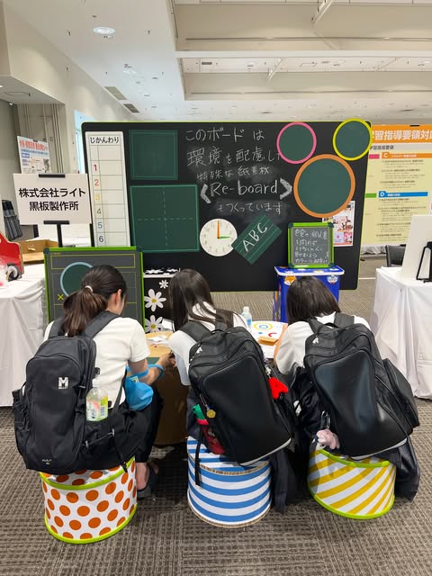 展示会ブースで、Re-board®製の黒板什器をご覧いただく様子です。